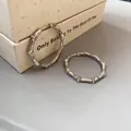 Detail view of silver-toned bamboo shaped hoop earrings decorated with shimmering zirconia stones. - Silver