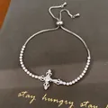 Gedetailleerd overzicht van een zilveren kruisarmband met glinsterende zirkonia - Kruis Stijl (6#)
