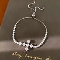 Detailopname van een zilveren zirkoon kruisarmband op een hoogwaardige donkere achtergrond - Kruisstijl (7#)