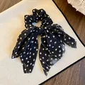 Detailed view of a black fabric bow scrunchie with classic white polka dot pattern - Bowknot Style / Black
