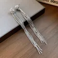 Detailopname van elegante zilveren geknoopte kwastjes oorbellen op een displaybord - Oorsteker Achterkant Alleen / Zilver