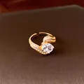 Detailansicht eines eleganten vergoldeten 18-Karat-Zirkonia-Rings, verstellbar. - Gold