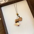 Gedetailleerde weergave van de houten berenhanger op een retro lange halsketting - Schattige Hond Bloem Stijl (4#)