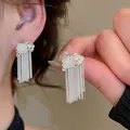 Gedetailleerd macro-beeld van zilveren vlinderkwastoorbellen met witte parels - Elegante Parel Vlinder Kwast Stijl (9#)