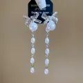 Detailopname van elegante zilveren strik oorbellen met hangende witte parels - Strik Onregelmatige Parel Kwast Stijl (17#)