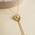 Dettaglio di un ciondolo vintage placcato oro 18k con perla centrale a raggiera - Collana / Oro