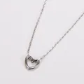 Vista detallada del collar con colgante de corazón de acero inoxidable con diseño calado - Color acero