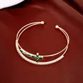 Dettaglio del bracciale a doppio strato placcato oro 18k con croce di zirconi verdi. - Zircone Verde / Oro