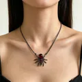 Detailweergave van donkere spin ketting met rode traan edelstenen op nek - Spinnenketting (10428)