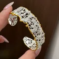 Primo piano dettagliato di un bracciale a fascia vintage traforato argento con bordi oro - Set Bracciale E Anello / Bicolore oro e argento