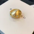 Gedetailleerde opname van een gouden ring met sterpatronen en glanzende zirkoonstenen - Geborstelde Ster Stijl / Goud
