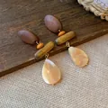 Detailed view of handmade wood and shell drop earrings with retro aesthetic on a rustic surface - Style 2 Silver Post Brown