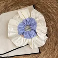 Detail van een grote crèmekleurige satijnen scrunchie met blauw gestreepte rand - Beige Satijn Blauwe Streep Stijl