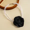 Detail of multi-layered pearl necklace featuring a large handmade black fabric rose. - Black
