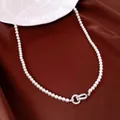 Detailansicht einer eleganten Perlenkette mit einer mit Zirkonia besetzten Verschlussspange - Weiß