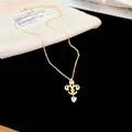 Vue détaillée d'un collier plaqué or 14K avec pendentif fleur de lys et cœur en zircon - Plaqué Or 14k / Or