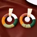 Gros plan de boucles d'oreilles créoles en corde de coton tissée style ethnique - Tige d'oreille en argent - Doré - Coloré