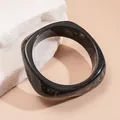 Close-up detail of a modern black marbled square bangle bracelet resting on white stones - 19# Bangle (Marble Pattern Style)