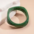 Close-up of a chunky green marbled resin bangle with a unique curved square design. - Style 22