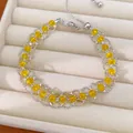 Détail d'un bracelet en maille argentée avec des perles de verre jaunes dans un écrin à bijoux. - Jaune
