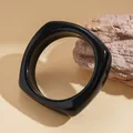 Detailed macro view of a high-gloss black geometric chunky bangle on a stone prop. - Rounded Square Style (35# Bangle)