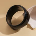 Close-up of a wide glossy black circular bangle on a minimalist beige background - Minimalist Round Style (38# Bangle)