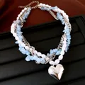 Vue détaillée du collier multicouche avec perles, pierres bleues et cœur en argent. - Argent-Blanc-Bleu
