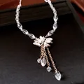 Macro view of elegant crystal floral pendant necklace with delicate gold chain dangles - Necklace - Gold - White