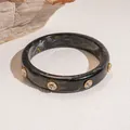 Elegante zwart gemarmerde hars armband versierd met luxe kristallen klinknagels - Zwart