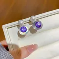Gros plan détaillé des boucles d'oreilles en résine avec zircon violet et perle - Boucles d'oreilles clous / Tige en Argent-Blanc-Violet