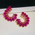 Luxe C-vormige oorbellen met magenta waterdruppelkristallen en een gouden afwerking - Zilveren oorbelsteker - Roze