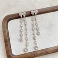 Detail of elegant silver bowknot tassel earrings with sparkling teardrop-shaped zircons. - Tassel Bow Style / Silver Earring Post Style / Silver