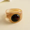 Nahaufnahme eines Vintage-Armreifs aus marmoriertem Acryl mit dunkelbraunem Stein - Rosa-Braun