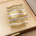 Vue détaillée du large bracelet manchette en métal ondulé doré et argenté - Style Plissé Ondulé / Or et Argent