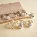 Detailed view of a seven-piece vintage silver ring set with pearls on a stone background - 7-piece Set / Silver