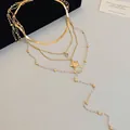 Nahaufnahme der filigranen mehrlagigen Goldhalskette mit Sternanhängern und Perlen. - Stern Mehrlagige Halskette / 4-teiliges Set / Gold