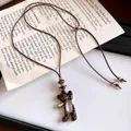 Gros plan d'un collier avec pendentif ours léopard et cordon en cuir marron vintage. - Ours en peluche / Marron