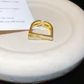 Macro view of minimalist geometric gold open ring with white inlay and zircon accents - Gold