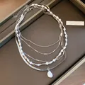 Detailansicht einer mehrlagigen Silberkette mit Barockperlen auf einem Displaytablett. - Mehrschichtige Barockperlen-Halskette 2er-Set (Silber-Weiß)