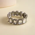 Close-up of vintage silver-tone stretch bracelet featuring radiant square-cut crystals. - Silver-Clear