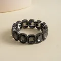 Detailed view of a vintage elastic bracelet featuring square-cut grey gemstones. - Gunmetal
