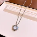 Dettaglio di una collana con orologio da taschino a cuore argento in un vassoio portagioie. - Cuore / Argento