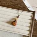 Gedetailleerd macro-aanzicht van een houten berenketting op een beige sieradenhouder - Hond Stijl