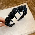 Detail of a black fabric polka-dot headband featuring non-slip plastic teeth - Wave Anti-slip Style With Teeth / Black