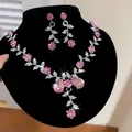 Gros plan détaillé sur un ensemble collier et boucles d'oreilles en cristal rose - Rose