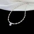 Macro detail view of elegant sparkling cubic zirconia pendant on a lustrous pearl necklace - Necklace / Silver-Pink
