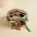 Close-up detail of retro multi-layered resin beaded bracelet with gold heart charm - Gold-Blue-Coffee
