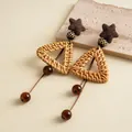 Detail of vintage rattan earrings with triangular woven design and brown glass tassels - Hollow Triangle Tassel Style / Brown-Coffee