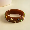 Detailed view of a vintage brown resin bangle with colorful 3D flower embellishments - Brown