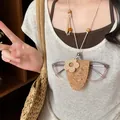 Detailansicht einer Boho-Halskette mit Brillenclip aus Leder und rustikalem Holzblumen-Anhänger - Blume / Braun
